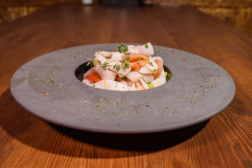 Plate with squid in white wine. Tasty food. Tasty seafood.