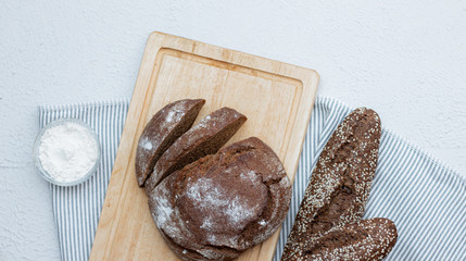 Black bread on a light background with space for text . Homemade fresh pastries. Bread with seeds.