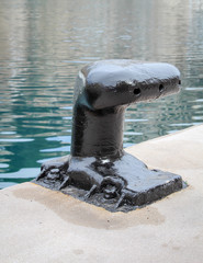 ein Poller an einer Kaimauer im Hafenbecken zum befestigen von Schiffen