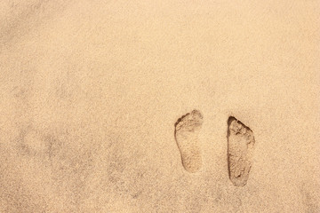 Human footprint on golden sand of tropical beach