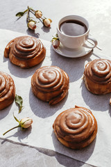 Cinnamon rolls and cream. Tea party. Still life. Vertical photo.