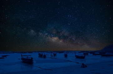 Milky Way with stars and fisherman boat on the beach. Amazing beautiful of night sky , Long...