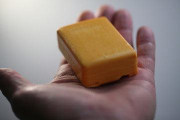 new dry  piece of yellow soap in the hands of a man