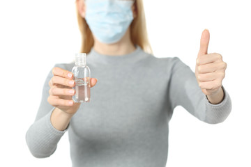 Woman with mask and sanitizer doing thumb up isolated on white