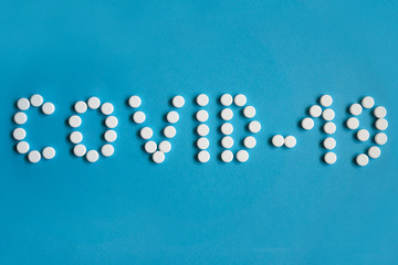 Coronavirus COVID-19 laid out from tablets on a blue background.