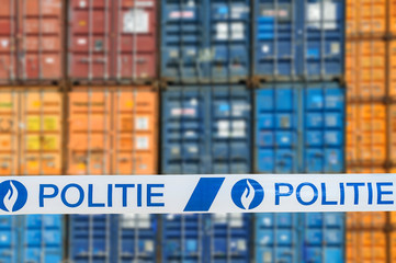 War on drugs. Politie / police tape in front of stacked containers waiting for transport on the...