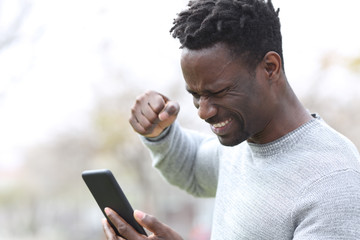 Angry black man checking content on smart phone