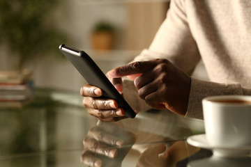 Black man hands checking smart phone at night