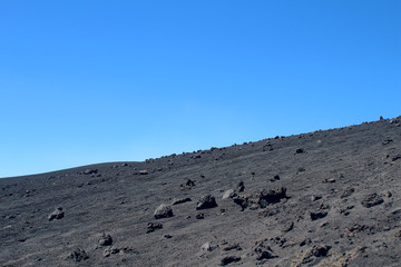 Black lava ash field under blue skies (Volcano Etna, Sicily, Italy)