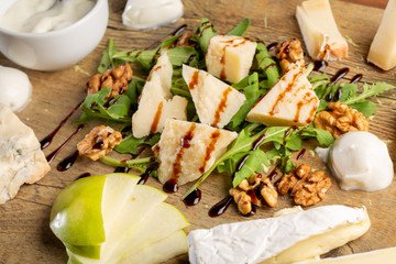 details of delicious cheese platter on a wooden board