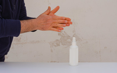 Disinfecting hands using antiseptic spray on hands to prevent coronavirus or flu disease.