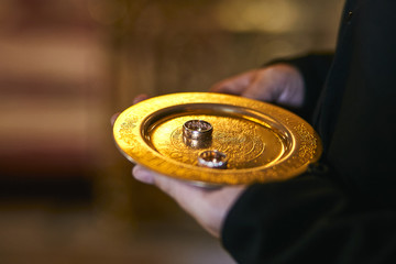 Two Golden Wedding Rings  on a  bronze plate