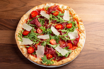 details of tasty italian ham and arugula pizza