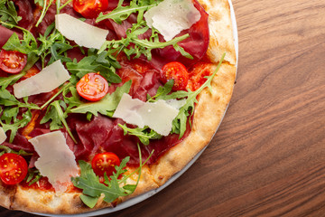 details of tasty italian ham and arugula pizza