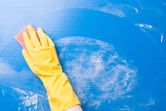 hand in rubber glove washes a blue surface from dirt with a paralon sponge, a trace in the form of an arc from a sponge, screen porosity after cleaning, before and after the concept