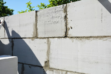 Building of a wall of a new house from autoclaved aerated concrete blocks.