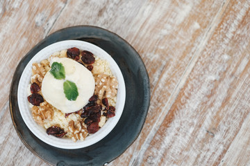 Apple crumble dessert with vanilla ice cream on the top on wooden table top view