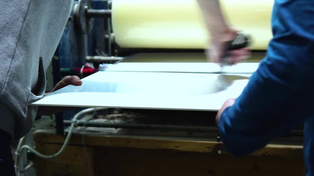 Close up of an operator cutting a  slab of glass. Operators working in a glass manufacturing industry manufacturing and processing of ESG glasses. 