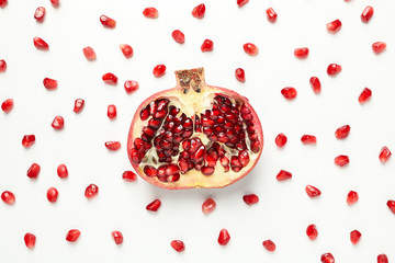 Flat lay with half of pomegranate and seeds on white background