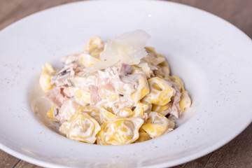 details of fresh, hot tortellini carbonara, with parmesan