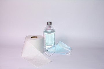 Toilet paper roll, protective mask and saline on white background
