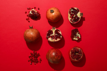 Flat lay with pomegranate on red background. Juicy fruit