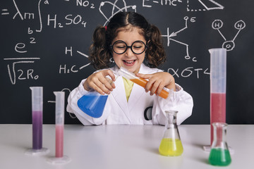 little scientist girl mixing chemical liquids