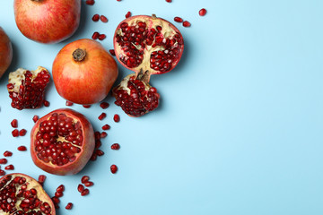 Pomegranate and seeds on blue background. Concept of juicy fruit