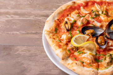 close up of sea food pizza on wooden background