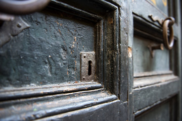 An old metal knocker on a old wooden door