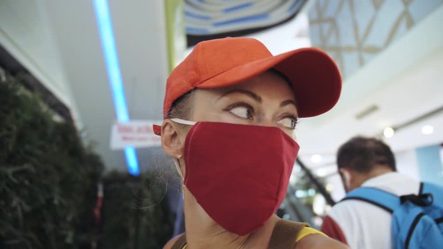 Woman travel caucasian visitor at a supermarket with wearing protective medical mask. Girl tourist customer a grocery store with protect respirator. Virus protection coronavirus pandemic covid-19.