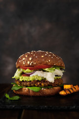Delicious fresh home made vegan lentils burger on a rustic dark background