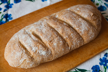 Freshly baked homemade bread on wooden cutting board.