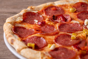 fresh tasty salami pizza on a wooden background