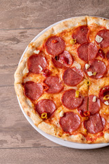 fresh tasty salami pizza on a wooden background