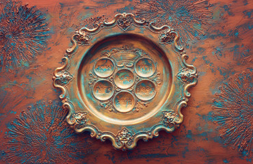 Pesah celebration concept (jewish Passover holiday). Traditional pesah plate text in hebrew: Passover, horseradish, celery, egg, bone, maror, sweet dates jam