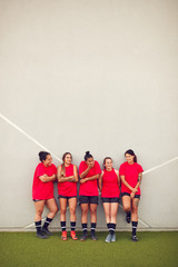 Obraz premium Graphic Shot Of Womens Football Team Leaning Against Wall Whilst Training For Soccer Match