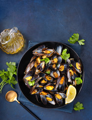 Vertical shot of cooked mussles on blue background