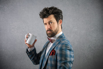 Funny portrait of business man in suit with red bow tie a coffee cup funny face
