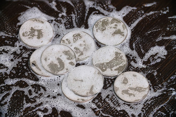 disinfection, washing, cleaning a handful of metal coins. one quarter dollar and liberty. soap and...
