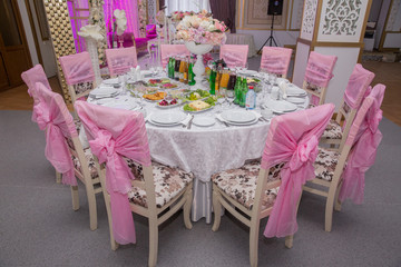 arrangements of decorations at wedding reception. expensive catering. space for text . salads and juices. luxury wedding decor with flowers and glass vases with jewels on round tables.