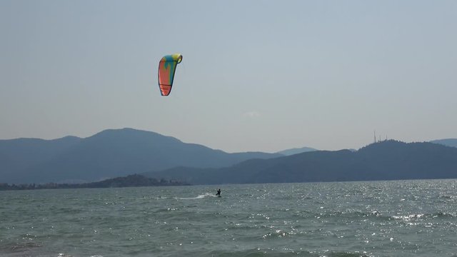 Fethiye, Turkey - 27th of Martch 2020: 4K Trekking shot Kitesurfer riding along the beach

