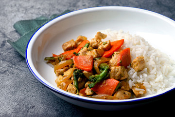 chicken and vegetable sauté with rice on a white plate