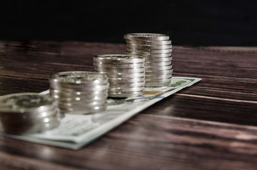 stack of coins on dollars .Business concept. The concept of cash savings. Coin Growth. Dramatic image. Dark background.