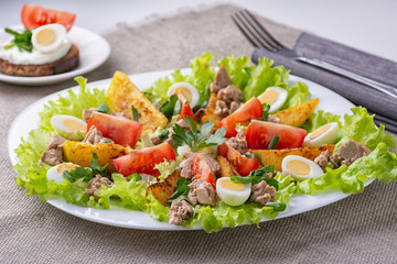 Nicoise salad with cod liver. Side view.