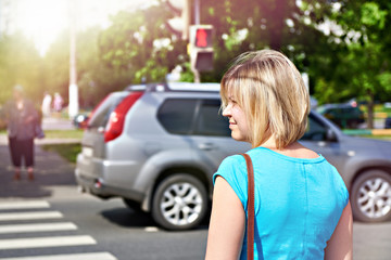 Woman stands on crosswalk waiting