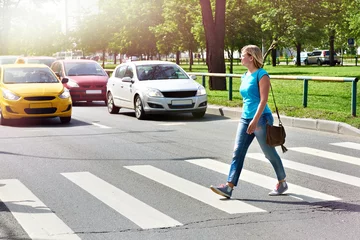 Deurstickers Woman crossing street at crosswalk © Sergey Ryzhov