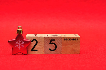 25 December on wooden blocks with a red star on a red background