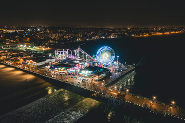 Santa Monica Pier at Night in super colourful lights from Aerial Drone perspective in Los Angeles,...