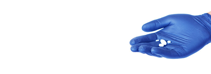 Banner with copyspace for text: the hand in the blue medical glove holding a tablets. Medicine, treatment and cure concept.